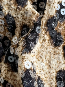 Close-up of leopard print bikini fabric featuring shiny sequin embroidery and textures