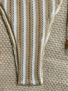 Detail of crochet knit striped bikini bottoms with beige and white woven texture
