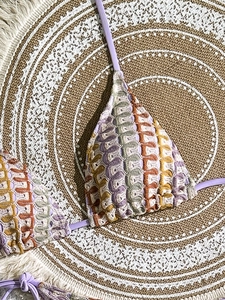 Close-up of colorful crochet halter bikini top featuring purple, orange, and green stripes