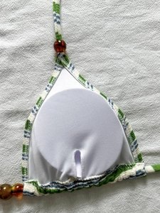 Dettaglio del top bikini a righe con perline d'ambra e imbottitura rimovibile