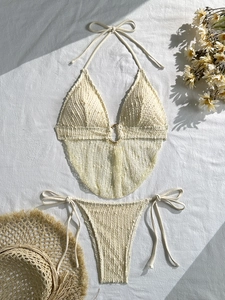 Set bikini all'uncinetto bianco panna con top allacciato al collo, laccetti e anelli d'oro