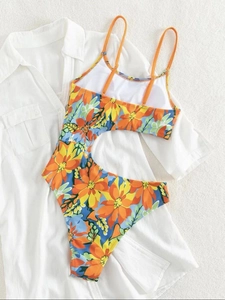 One-piece swimsuit with floral print and side cutouts on a tropical vacation background