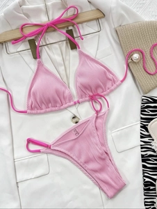 Flat lay of pink ribbed bikini set with neck tie top and high cut string bottoms