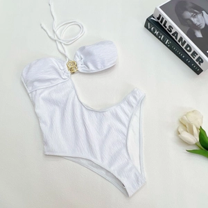 Detail of white textured one-piece swimsuit with asymmetric cut and golden metal buckle