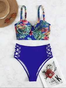 Detail of blue bikini with tropical print and high-waisted side lace-up cutout bottoms