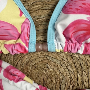 Close-up of floral bikini top with pink leaf prints, blue trim and brown bead details