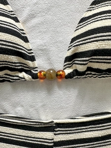 Set bikini a righe con tessuto testurizzato e perline decorative su fondo in lino