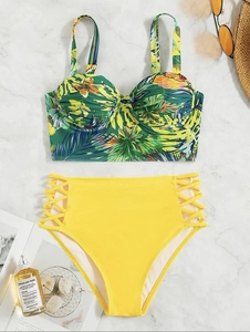 Flat lay of tropical floral bikini top with yellow high-waisted cutout bottoms