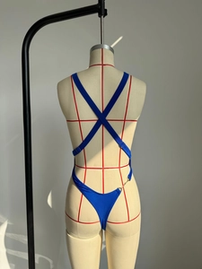 Détail du maillot de bain bleu avec bretelles croisées au dos et décor de chaîne dorée