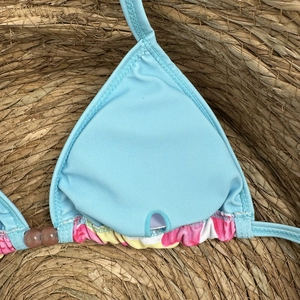 Detail of light blue halter bikini top with floral ruffles and brown bead accents