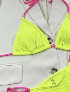 Detail of ribbed neon bikini fabric texture with contrast pink ties and metal ring