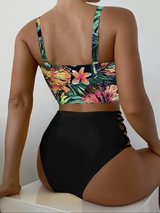 Detail view of high-waist bikini bottoms with side lace-up cutout and floral print top