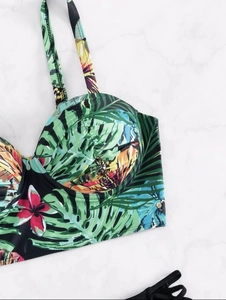 Detail of underwire bikini top featuring tropical leaf prints and ruched cup fabric