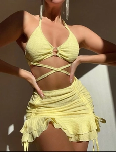 Détail du haut licou jaune avec anneau en métal et jupe froncée en tissu seersucker