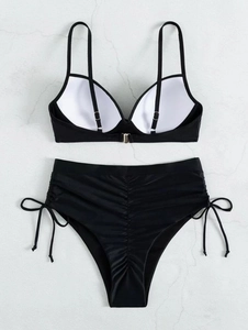 Close-up of black bikini set featuring ruched high-waist bottoms and silver metal clasp