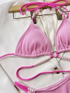 Bikini rosa a coste con perle decorative e anello in metallo dorato su gruccia