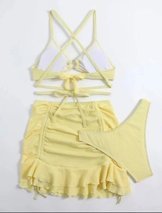 Détail d'un bikini jaune 3 pièces avec texture en nid d'abeille et jupe à volants