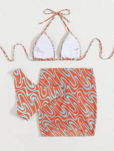 Detail view of a 3-piece bikini set with wave patterns and a mesh sarong beach skirt