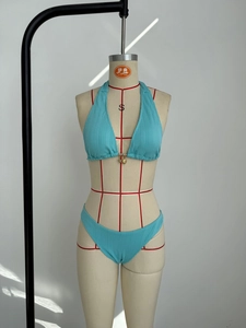 Detail view of sky blue ribbed bikini fabric with halter design and metal pendant