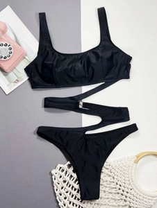 Detailed close-up of a black one-piece swimsuit featuring cut-out design and metal buckle