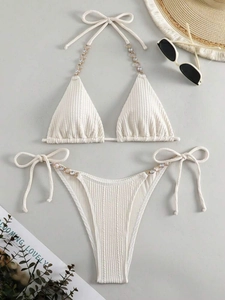 Flachbild von cremefarbenem Ripp-Bikini-Set mit eleganten Strassketten-Details und Strohhut