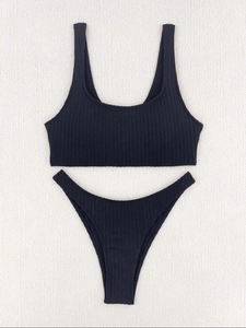 Flat lay of black ribbed two-piece bikini featuring high-cut bottoms and tank style top