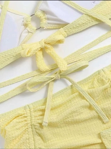 Détail d'un bikini jaune clair avec texture seersucker et bretelles croisées au dos