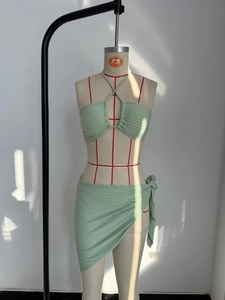 Detalle de la textura acanalada verde claro en el top bikini y el pareo a juego