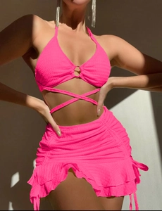 Détail du bikini rose fluo avec tissu texturé, anneau métallique et jupe à cordon
