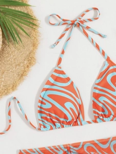 Detail of blue and orange wave pattern on a string bikini set with beach accessories