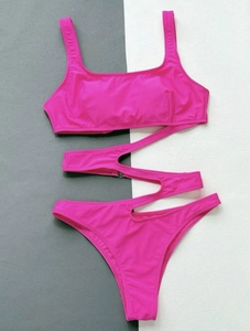 Detailed view of neon pink one-piece monokini with asymmetric cut-outs and square neckline