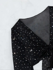 Detail of sheer black mesh swim cover-up with sparkling sequins and tie-front V-neck