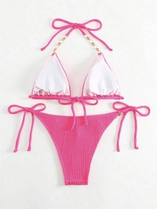 Details des pinkfarbenen Bikinis mit goldenen Ketten und geripptem Stoff