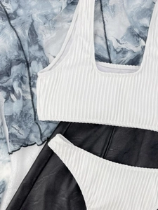 Detail view of white ribbed fabric texture on a high-elasticity bikini swimwear set