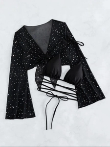 Detail of black bikini top and sheer mesh cover-up with sparkling star patterns
