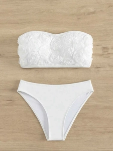 Detailed flat lay of white bikini set featuring 3D chiffon floral petals on tube top