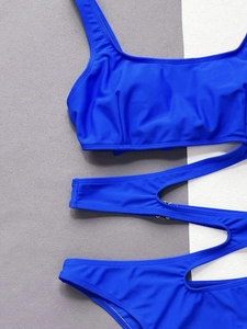 Detailed flat lay of bright blue swimsuit featuring cut-out straps and square neckline