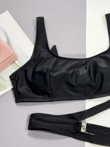 Macro shot of black swimsuit top with silky texture and silver buckle detail