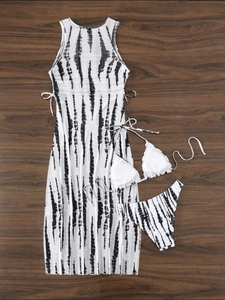 Three-piece bikini set with tie-dye mesh cover-up dress on dark wood background