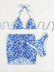 Three-piece bikini set with blue and white wave print featuring a matching sarong skirt