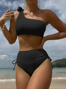 Detail of ribbed black one-shoulder bikini top with bow and drawstring high waist bottom