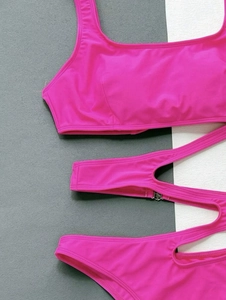 Detail of pink bikini with cutout strap design and metal buckle on high-stretch fabric