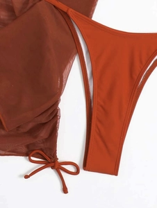 Détail du bas de bikini rouge rouille et ensemble assorti en maille avec cordon