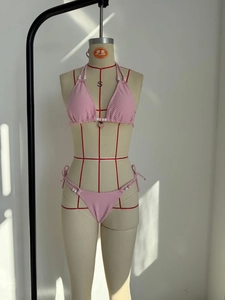 Détail d'un ensemble bikini rose avec pendentif fraise et tissu texturé sur mannequin