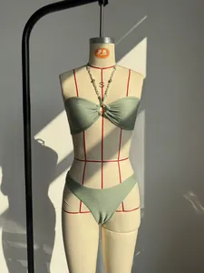 Dettaglio del top bikini verde testurizzato con catena dorata e spalline di perle
