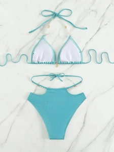 Détail d'un bikini turquoise avec décor de coquillages et pendentif étoile de mer