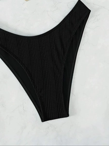 Detailed macro view of black high-cut bikini bottoms with a premium ribbed texture finish