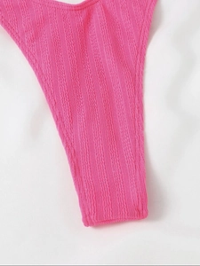 Détail du tissu texturé rose vif avec motif à vagues et couture pour maillot de bain