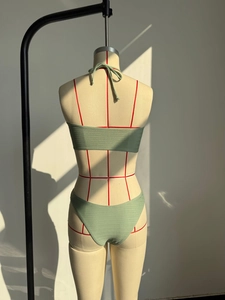 Dettaglio posteriore di un bikini a fascia verde chiaro in tessuto testurizzato
