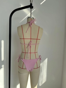 Vue arrière d'un bikini rose texturé avec liens à nouer sur un mannequin de couture